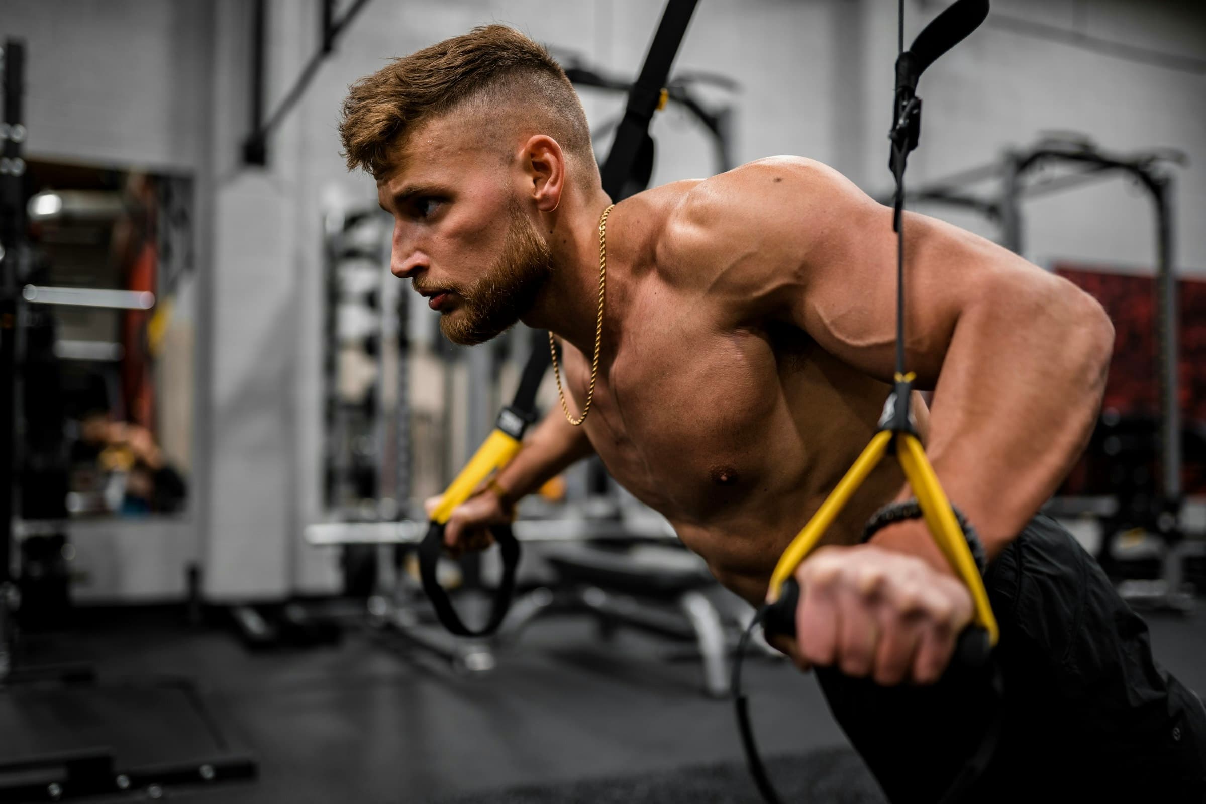 Athlète musclé qui s’entraîne aux sangles de suspension